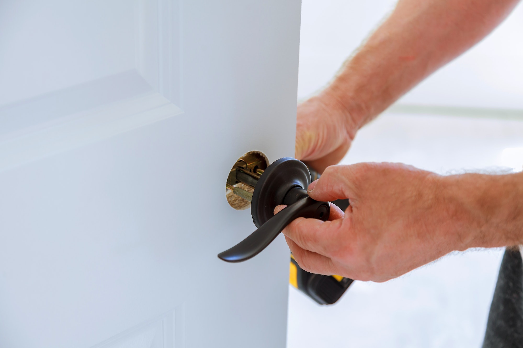 carpenter Installing the lock on the door Installation of the door lock.